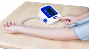 Arm with blood pressure cuff and digital monitor on table ready to start measurement